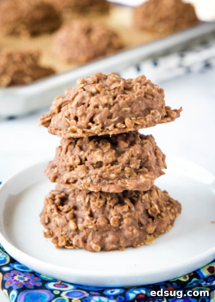 Classic Chocolate, Peanut Butter, and Oats No Bake Cookies stacked on a white plate, ready to eat.