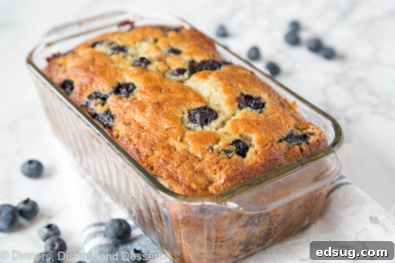 Freshly baked and sliced blueberry banana bread on a wooden board