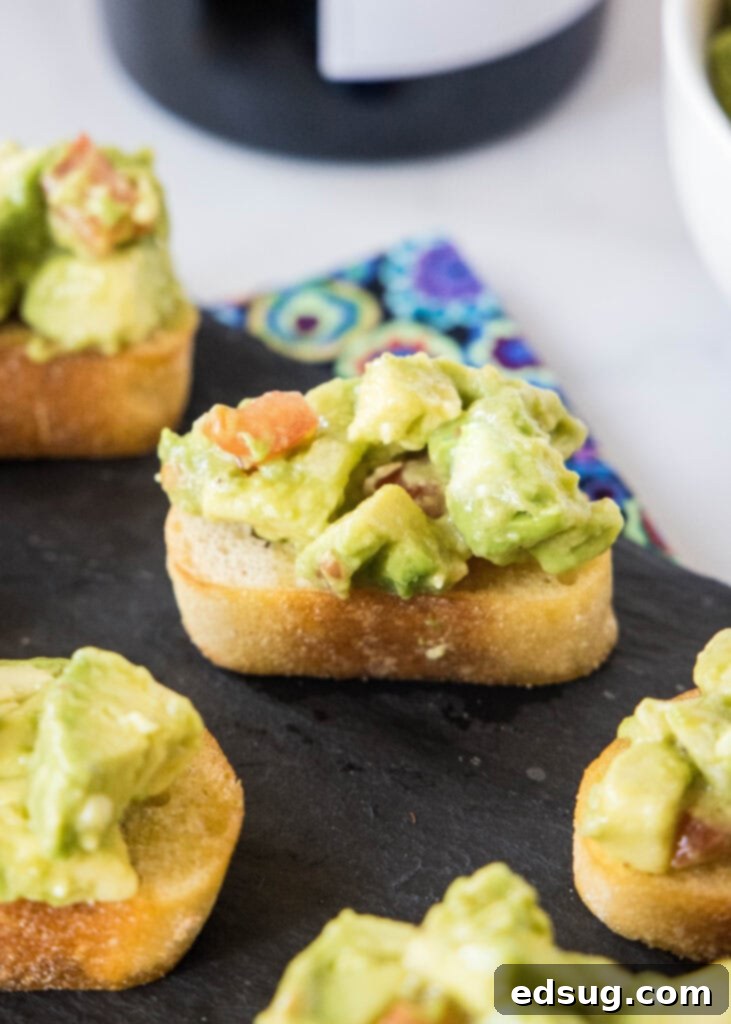 Delicious avocado bruschetta appetizers arranged on a rustic wooden serving tray, garnished with fresh herbs.