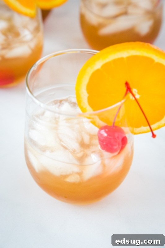 Classic Amaretto Sour Recipe 4 Easy amaretto sour recipe, showing a hand holding the finished cocktail with garnishes, emphasizing its approachable elegance.