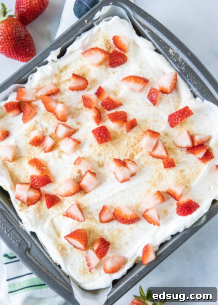 The fully assembled strawberry lush dessert in a baking pan, ready to be chilled and served.