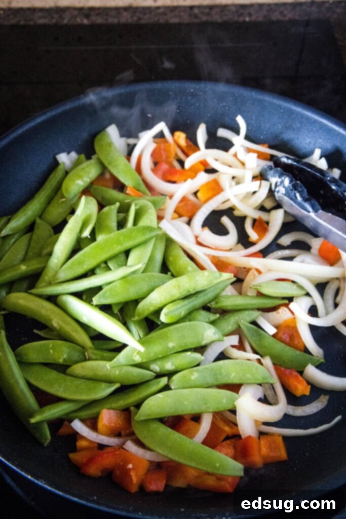 Fiery Chicken Stir Fry 4 Fresh bell peppers, onions, and snap peas stir-frying in a hot pan