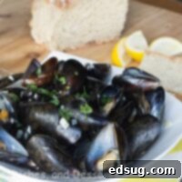 Freshly steamed mussels in a garlic, butter, and white wine broth, ready to be served.