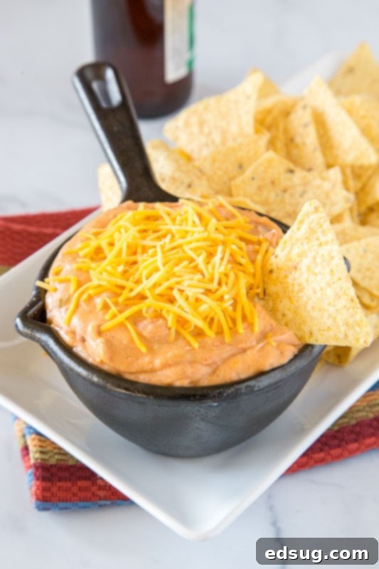 Effortless Refried Bean Dip 4 Easy, creamy, and cheesy refried bean dip served with chips at a party.