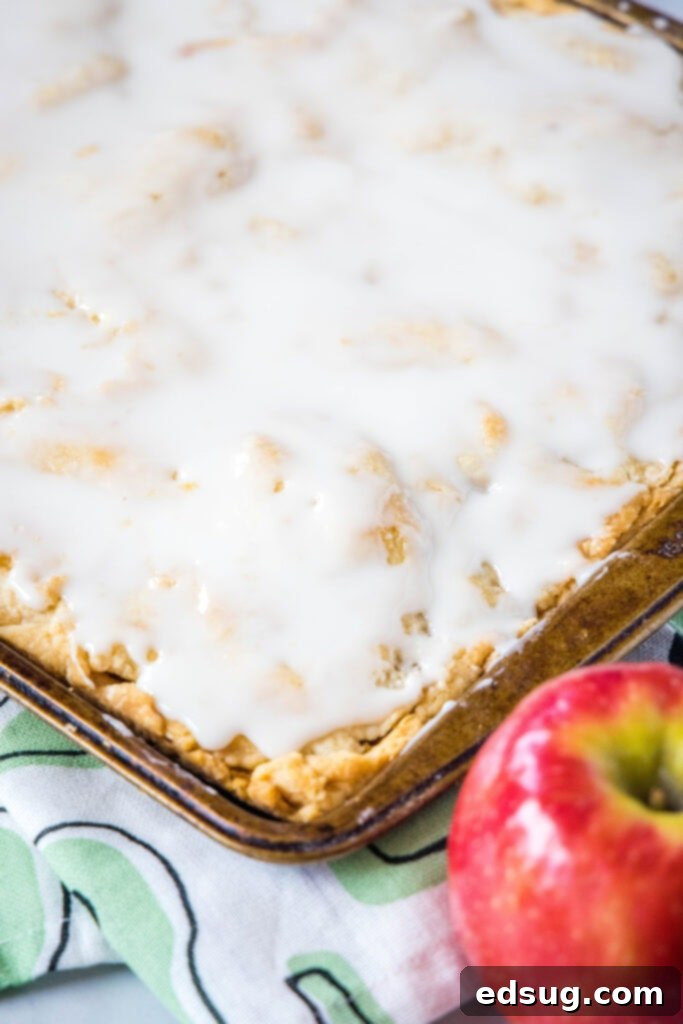 Apple Crumble Bars 3 apple bars topped with vanilla glaze in pan