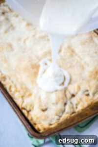 Apple Crumble Bars 10 pouring glaze over baked apple bars