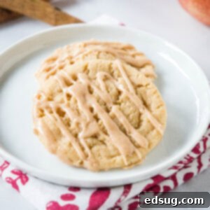 Spiced Apple Cider Cookies 6 Two apple cider cookies drizzled with cider glaze on a white plate.