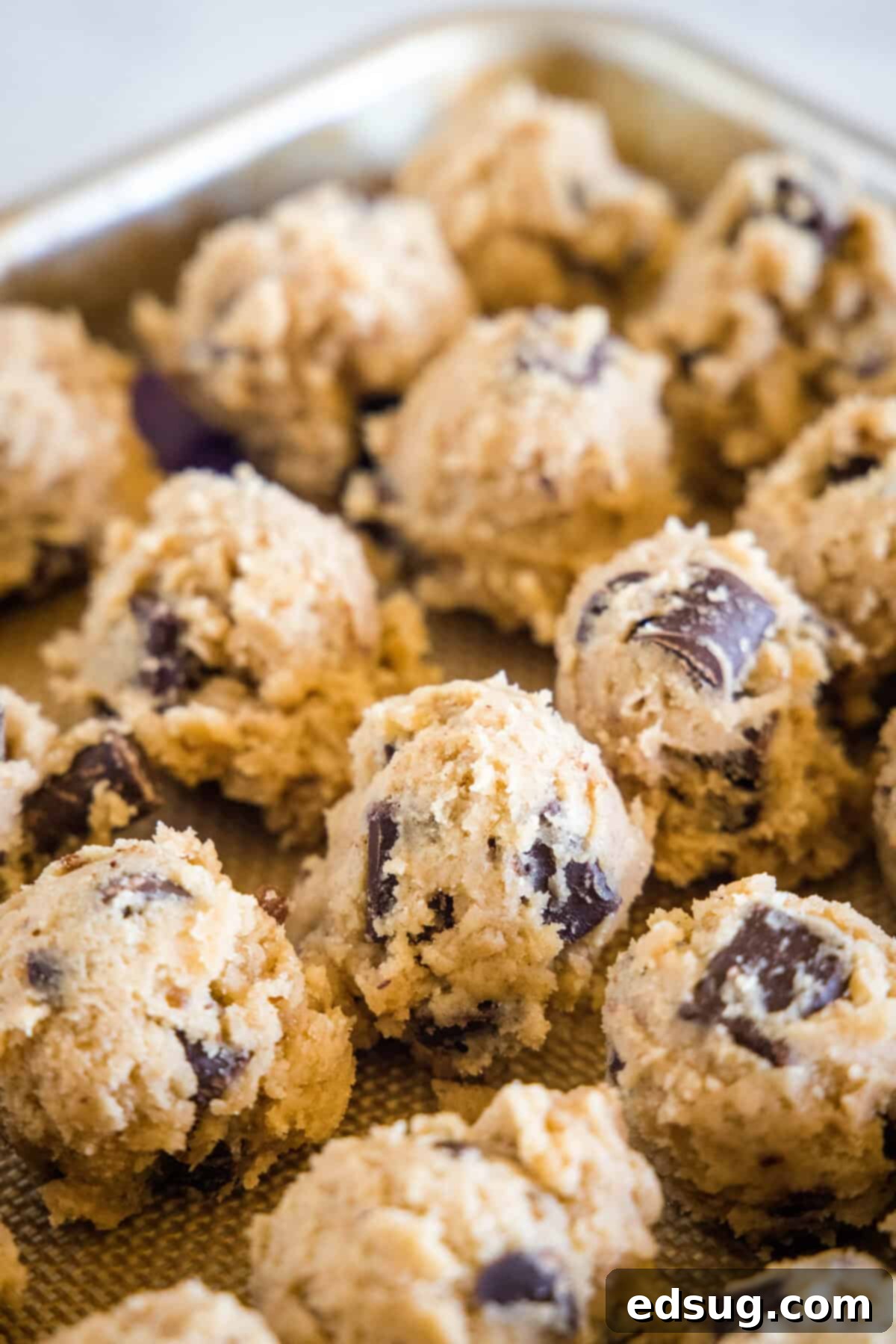 Spiced Mexican Chocolate Chip Cookies 4 Cookie dough balls neatly arranged on a baking sheet, ready for baking.