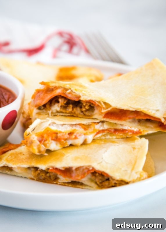 Crispy Pizza Quesadilla filled with pepperoni, sausage, peppers, and cheese, served with pizza sauce for dipping.