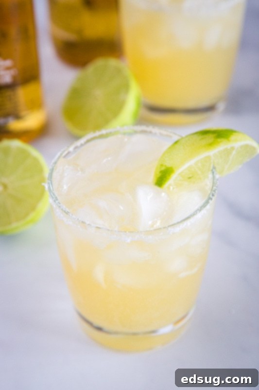 The Ultimate Beer-Garita 3 Three simple ingredients laid out on a table: a can of frozen limeade, a bottle of white tequila, and two bottles of light beer, ready to be mixed for easy beergaritas.