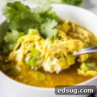 Close-up of ginger chicken soup in a white bowl, ready to be served.