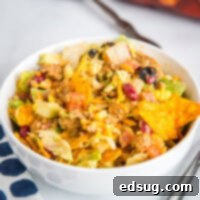 A bowl of food on a plate, with Salad and Taco