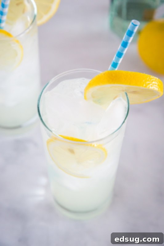 Close-up of a Tom Collins cocktail, showcasing the clear, fizzy drink with lemon slices and ice, emphasizing its refreshing appeal.