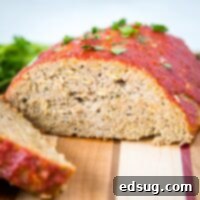 A slice of meatloaf sitting on top of a wooden cutting board, with Dinner and Meatloaf