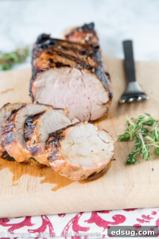 Succulent Herb-Marinated Grilled Pork Tenderloin 2 A perfectly grilled pork tenderloin, sliced into medallions and garnished with fresh herbs, showcasing its juicy interior and golden-brown crust.
