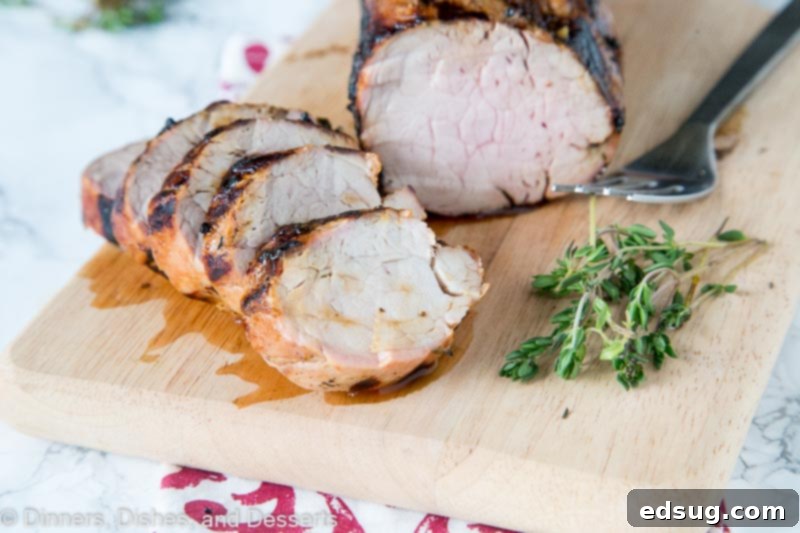 Succulent Herb-Marinated Grilled Pork Tenderloin 3 A piece of raw pork tenderloin resting in a vibrant herb and lemon marinade, ready to absorb flavors before grilling.