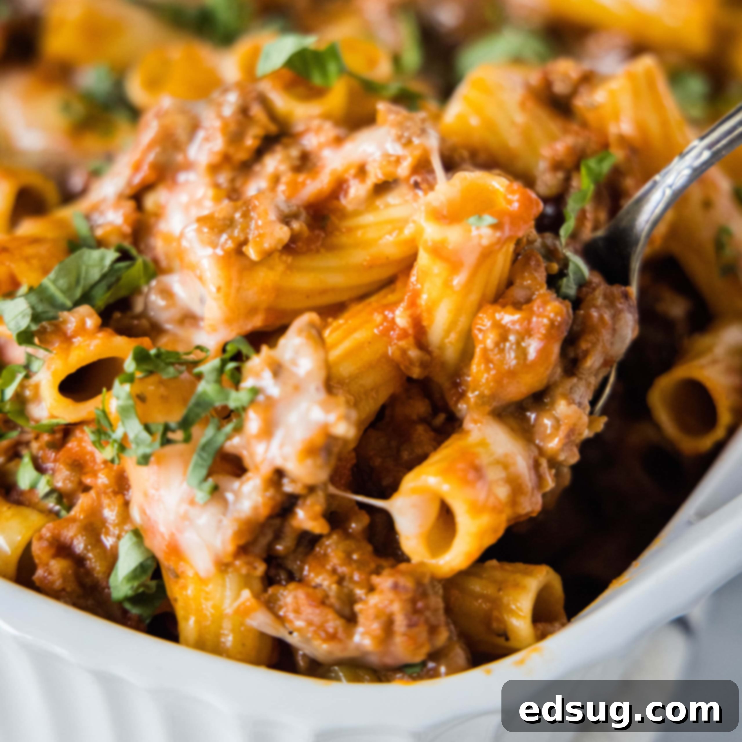 close up scooping sausage casserole out of baking dish