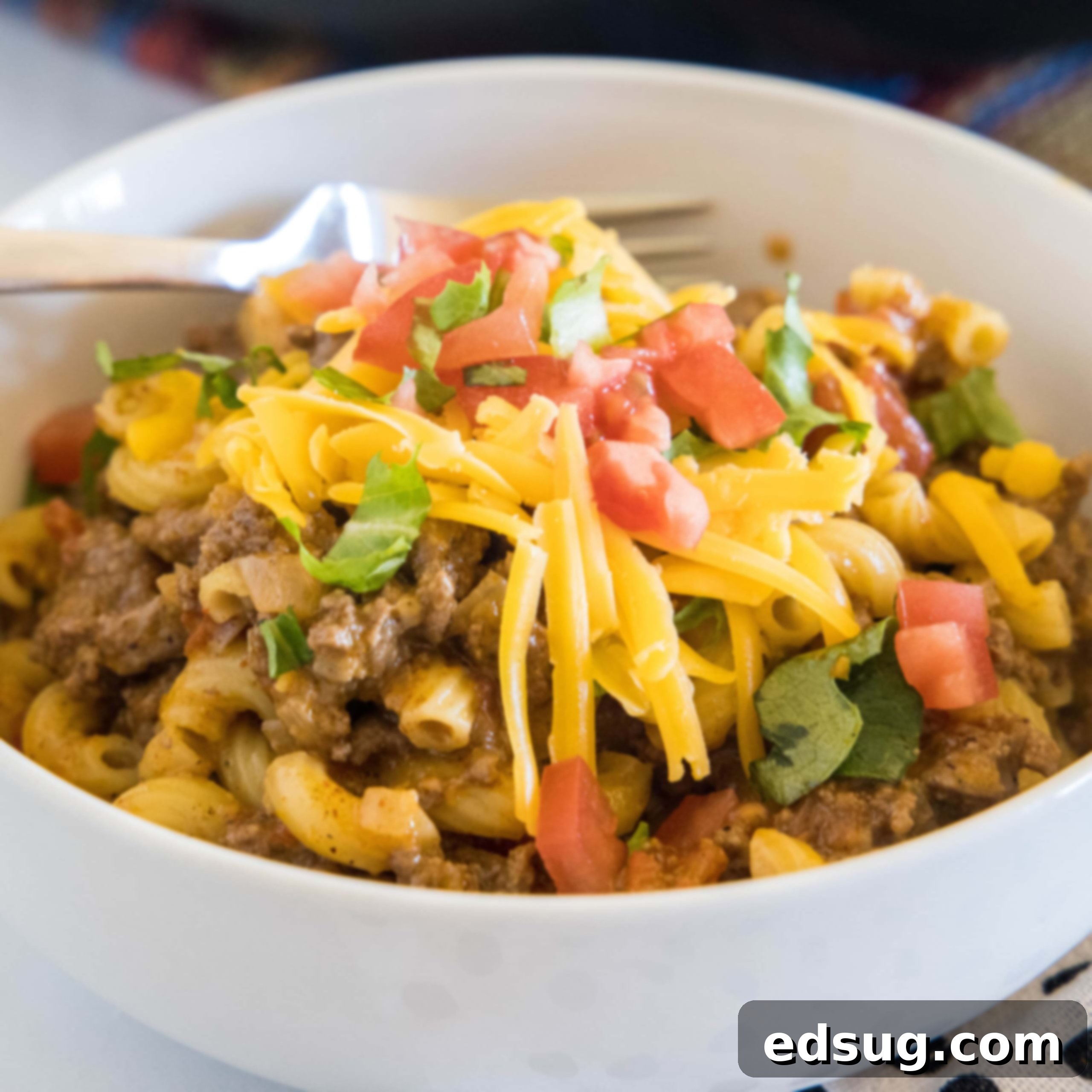 A bowl of taco mac and cheese with a fork.