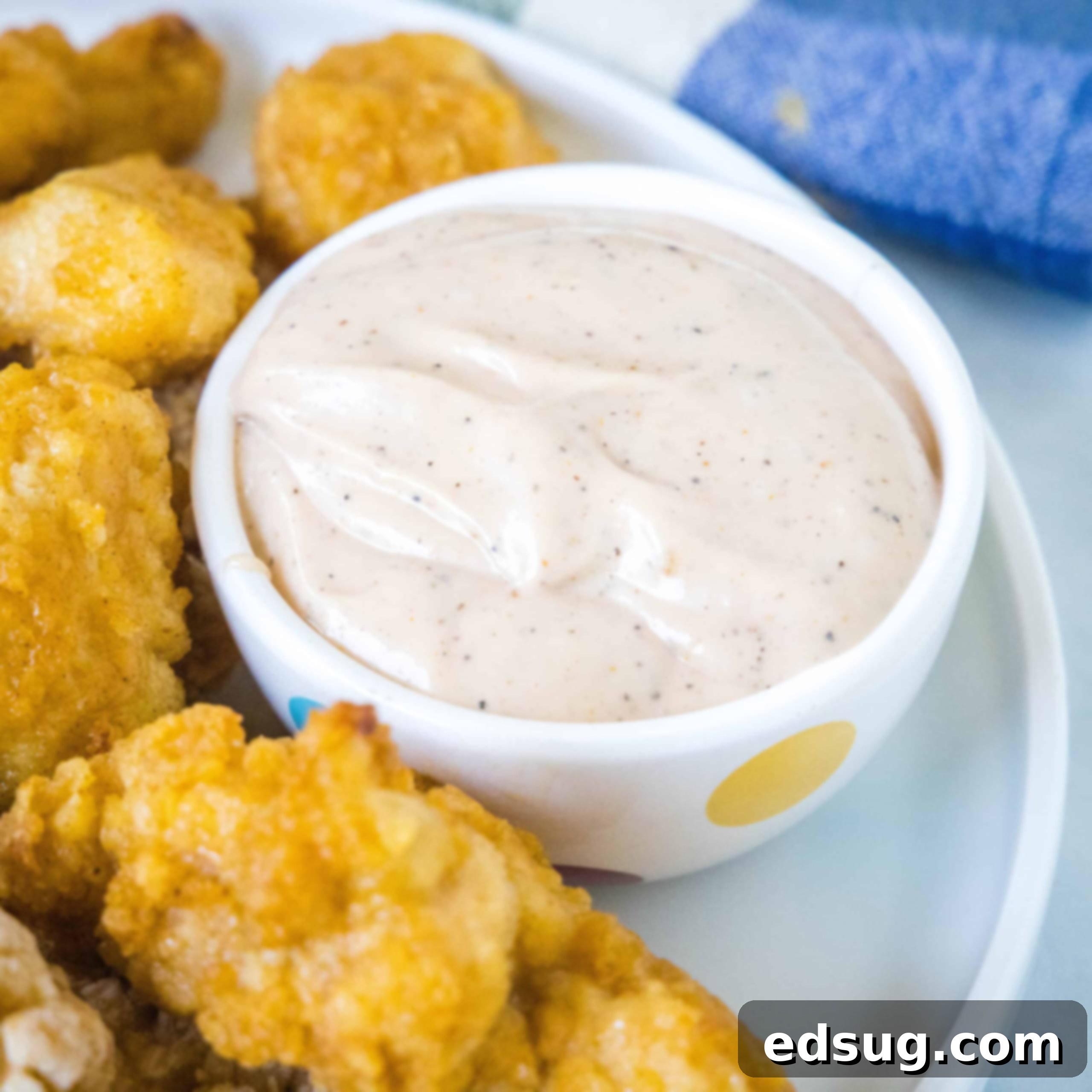 A small bowl filled with creamy, tangy Raising Cane's Sauce, perfect for dipping.