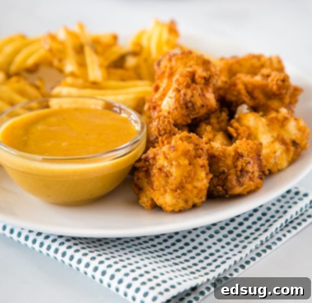 Crispy Chick-Fil-A Chicken Nuggets served on a plate with golden fries and a delicious dipping sauce.
