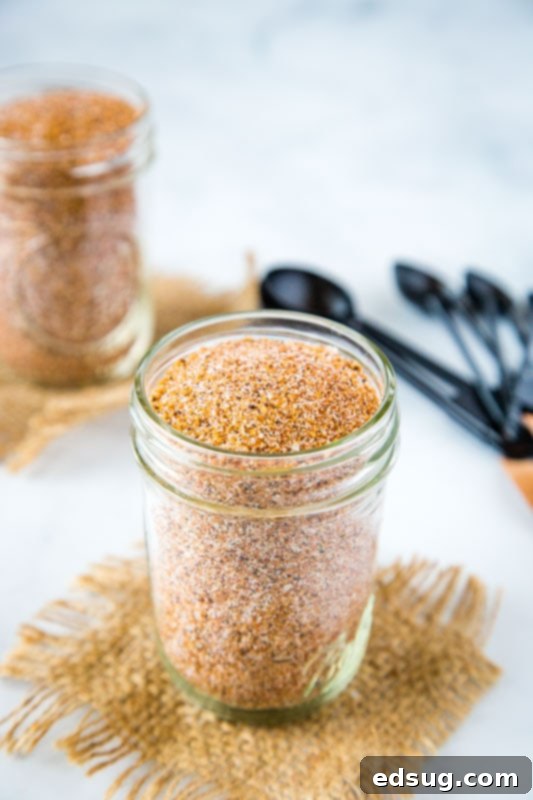 Easy dry rub for ribs being scooped from a jar onto a cutting board, highlighting homemade freshness