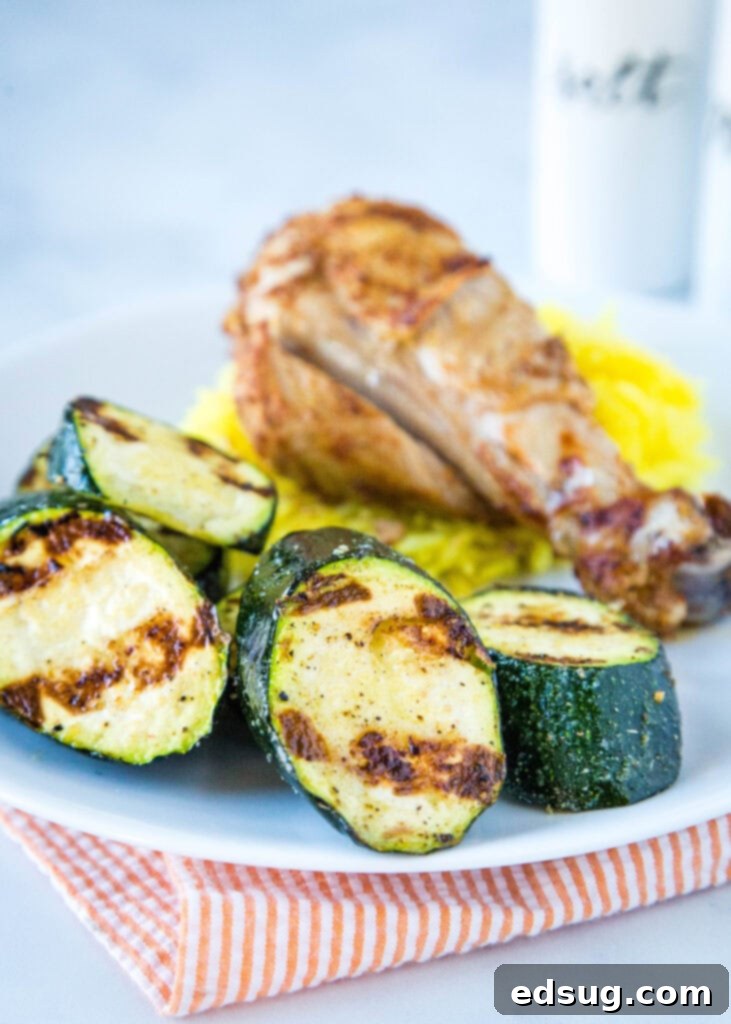 zucchini with grilled chicken and rice on a white plate
