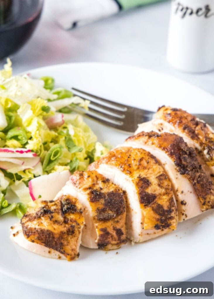 Smoked Chicken Perfection 5 Sliced smoked chicken served on a white plate with a side salad, showcasing its juicy texture