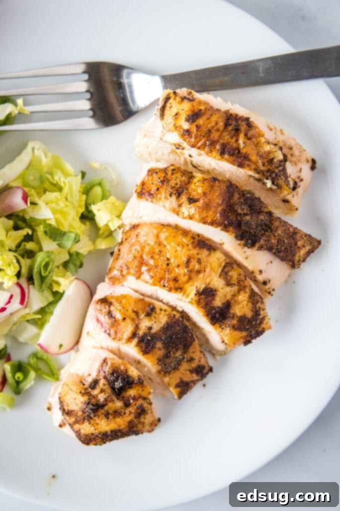 Smoked Chicken Perfection 6 Close up view of perfectly sliced smoked chicken on a white plate, highlighting its moist texture