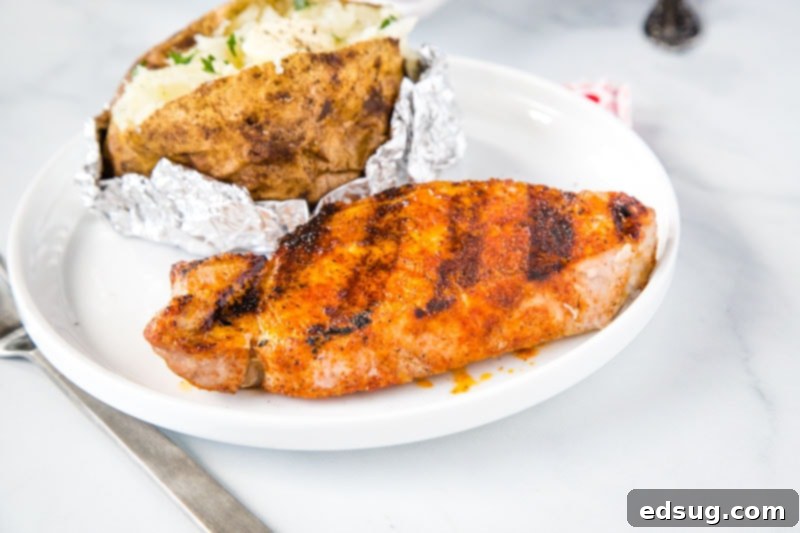 Sizzling Pork Chops 5 Overhead view of perfectly grilled pork chops, seasoned with simple spices, on a white background. They are juicy, tender, and ideal for an easy summer dinner.