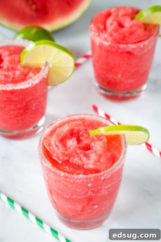 Fresh Watermelon Margaritas 3 Homemade watermelon flavored margaritas in elegant glasses, adorned with fresh lime slices, ready to be served.