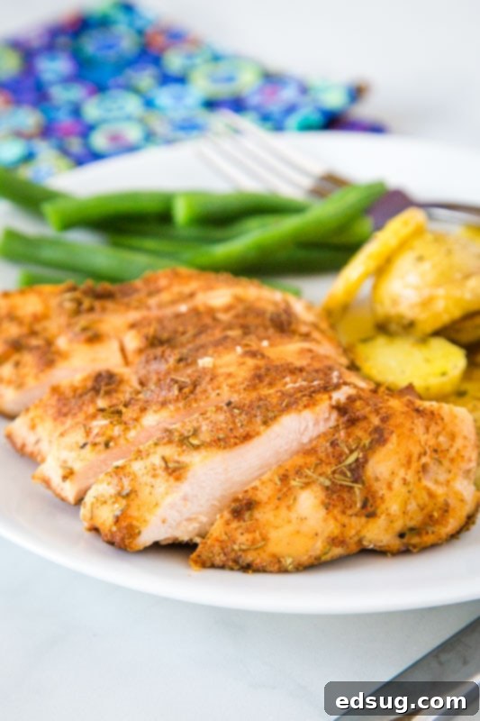 Cut up chicken breast on plate with green beans and potatoes
