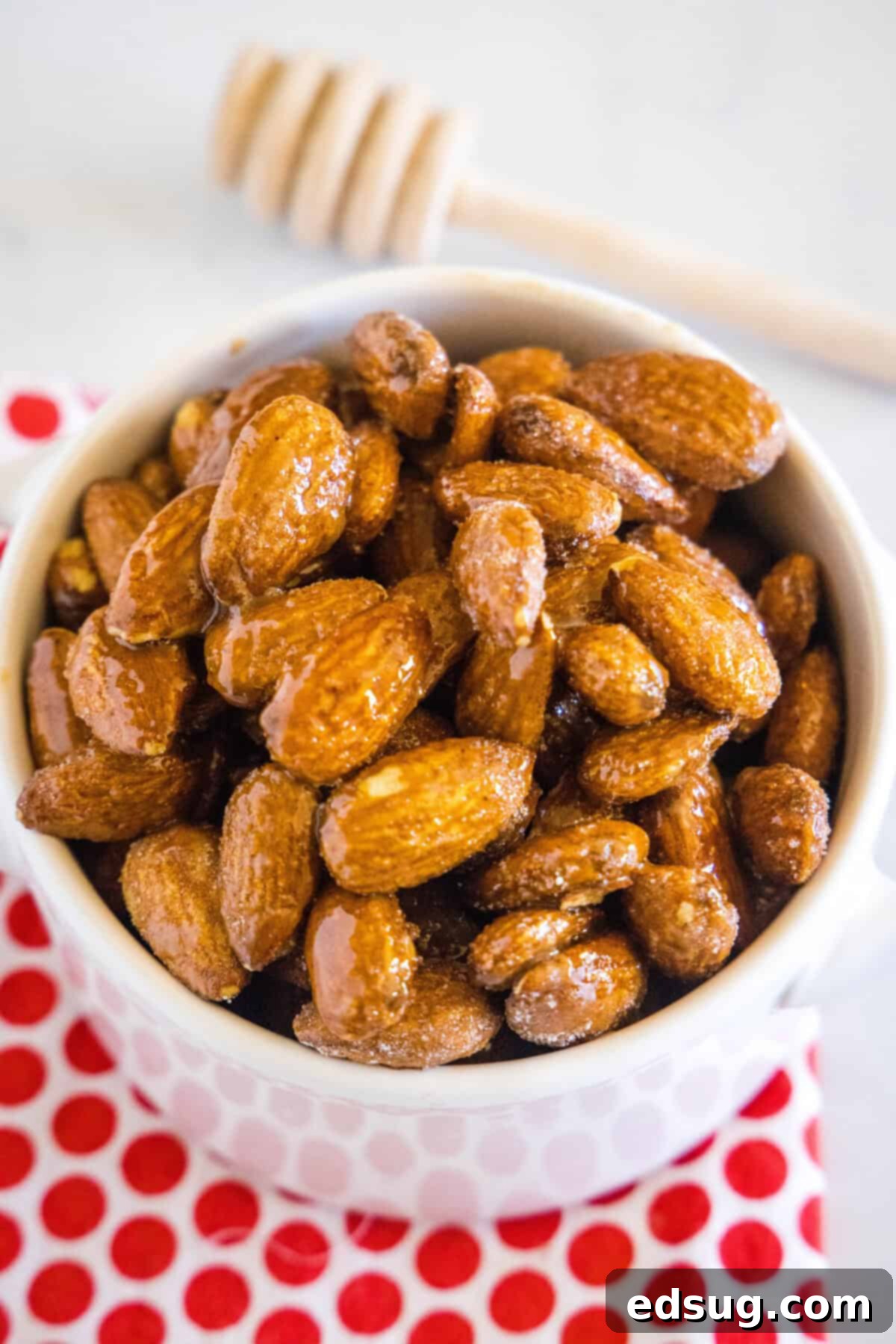 Spicy Honey Roasted Almonds 3 A inviting close-up of sweet and spicy almonds piled high in a rustic white bowl, ready for snacking.