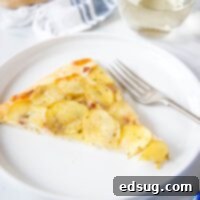 Golden Potato Pizza 7 Close up of a delicious slice of potato pizza with thinly sliced potatoes, melted cheese, and a crispy crust.