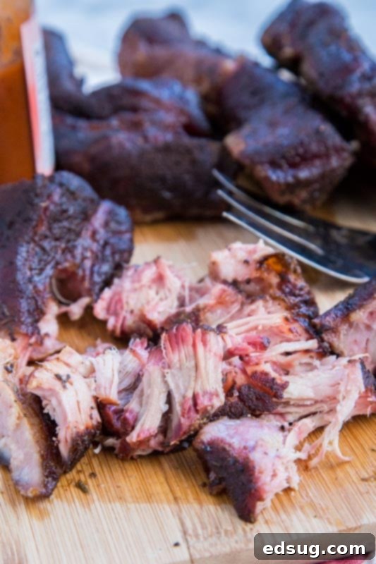 shredded country style ribs on cutting board with fork
