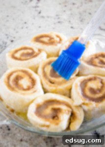 Warm Cinnamon Swirls 13 brush butter on cinnamon rolls in the pan