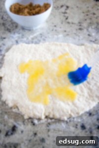 Warm Cinnamon Swirls 9 dough rolled out being brushed with butter