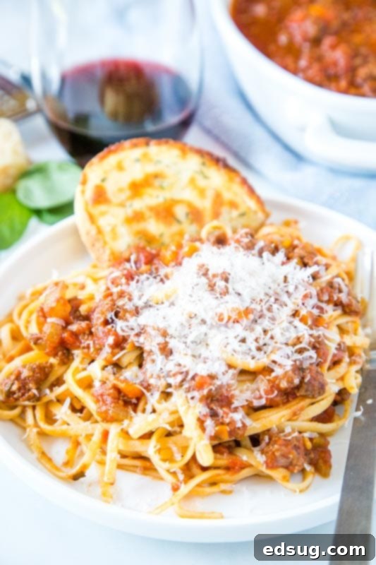 Quick Instant Pot Bolognese 2 Plate of pasta with meat sauce topped with parmesan cheese, highlighting the rich texture and hearty ingredients of Instant Pot Bolognese.