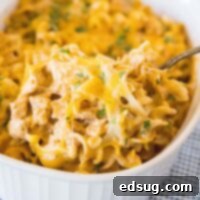 close up scooping chicken pastas out of baking dish