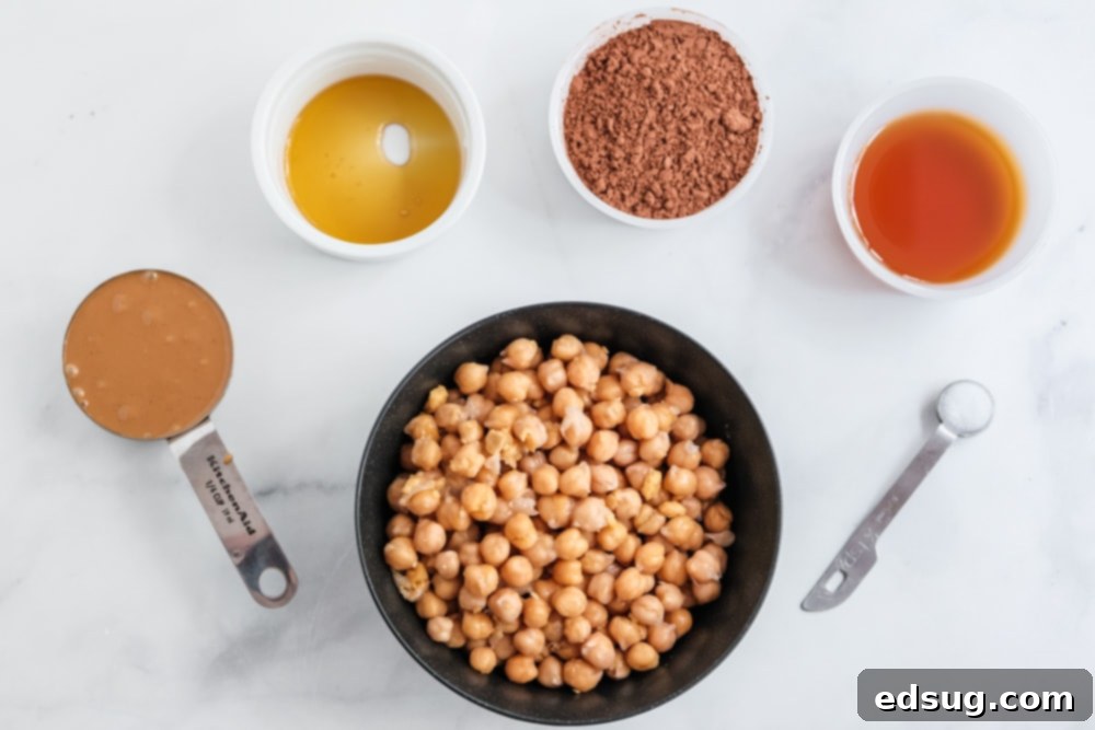 Sweet Chocolate Hummus 3 a flat lay of chocolate hummus ingredients including chickpeas, peanut butter, maple syrup, cocoa powder, vanilla extract, and salt, arranged for an overhead shot