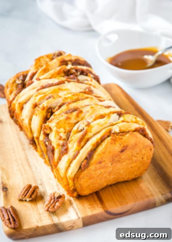 Freshly baked pumpkin pull apart bread cooling on a wooden cutting board