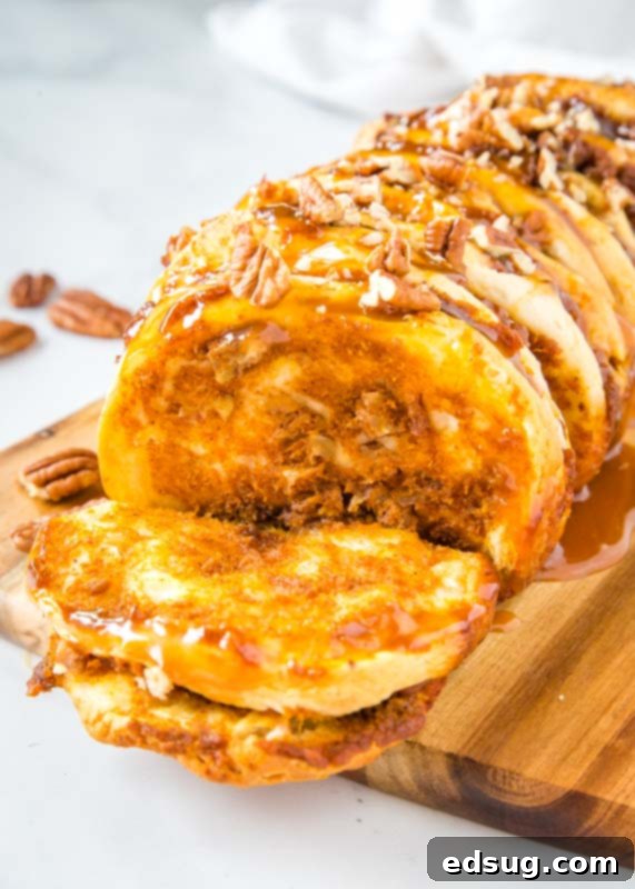 Close-up of a piece of pumpkin pull apart bread torn off, showing layers of caramel and pecans