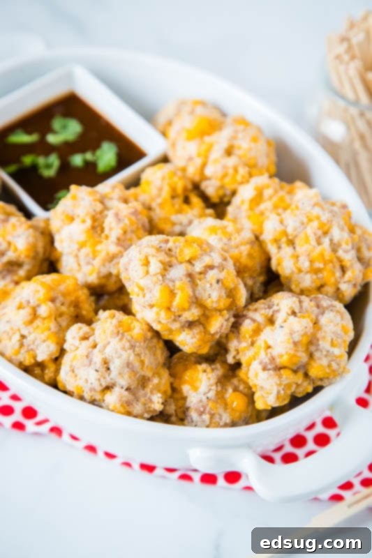 Cream Cheese Sausage Balls 3 cheesy sausage balls in white dish with barbecue sauce