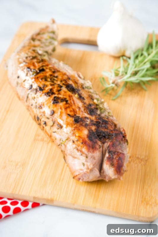 Perfectly cooked sous vide pork tenderloin on a wooden cutting board, ready to be sliced