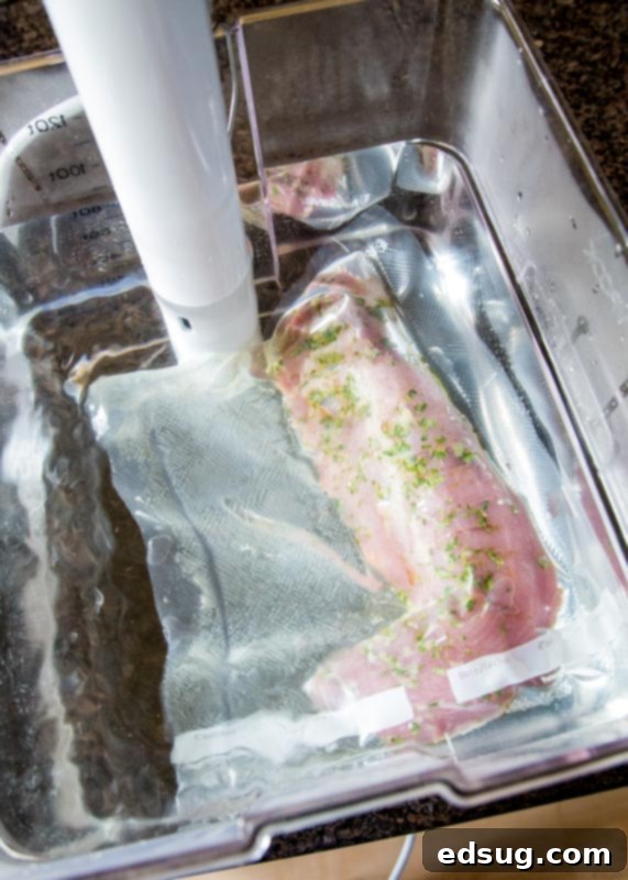 Pork tenderloin cooking in a clear water bath with a sous vide circulator