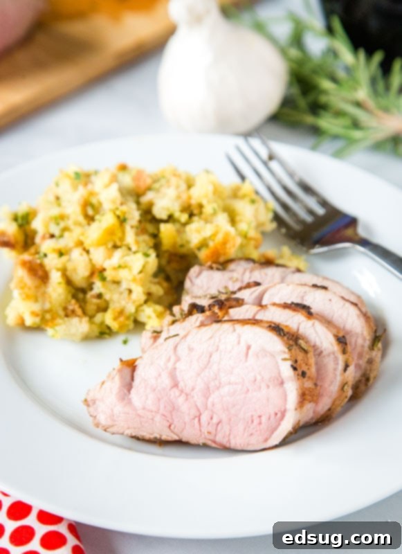 Sliced sous vide pork tenderloin served on a plate with stuffing as a side dish