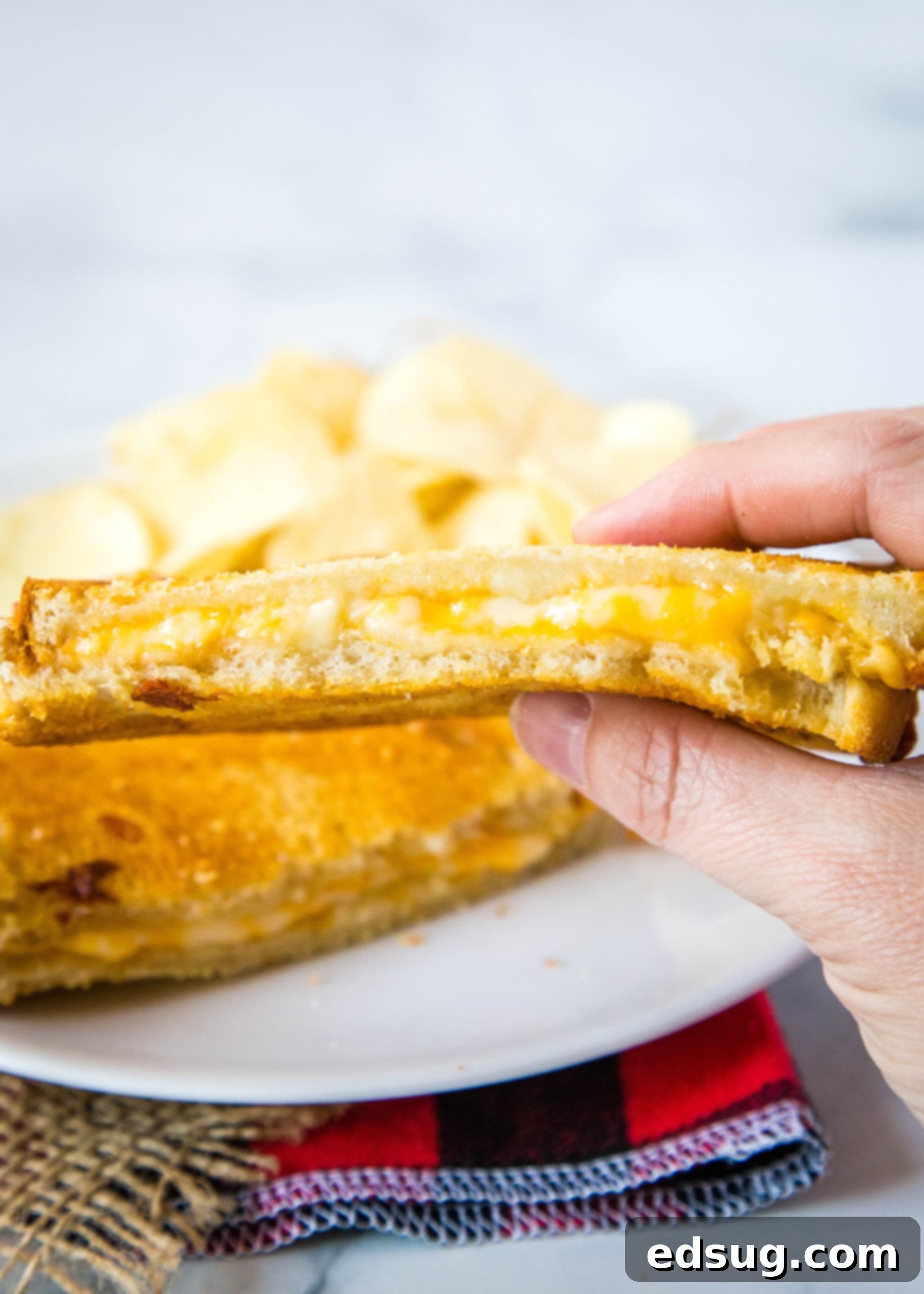 Crispy Air Fryer Grilled Cheese 3 a person holding half a grilled cheese sandwich