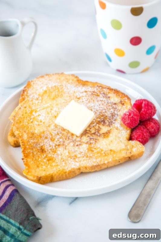Golden Sourdough French Toast 4 Sourdough french toast on a plate topped with a pat of butter, ready to be drizzled with syrup.