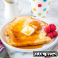 cropped picture of french toast on plate with butter and syrup
