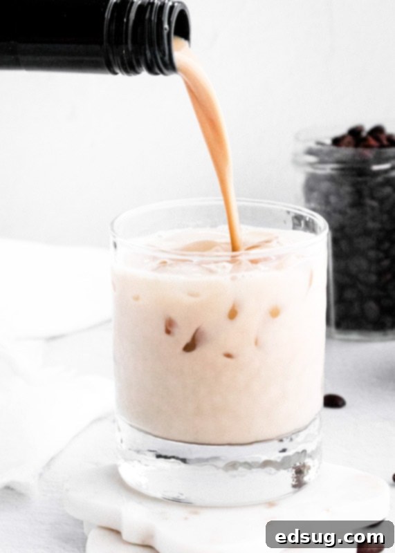 The Perfect Baileys White Russian 3 Baileys being poured into a cocktail glass, creating a beautiful swirl.