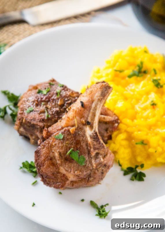 Two perfectly seared sous vide lamb chops resting on a bed of risotto, garnished and ready to be served.